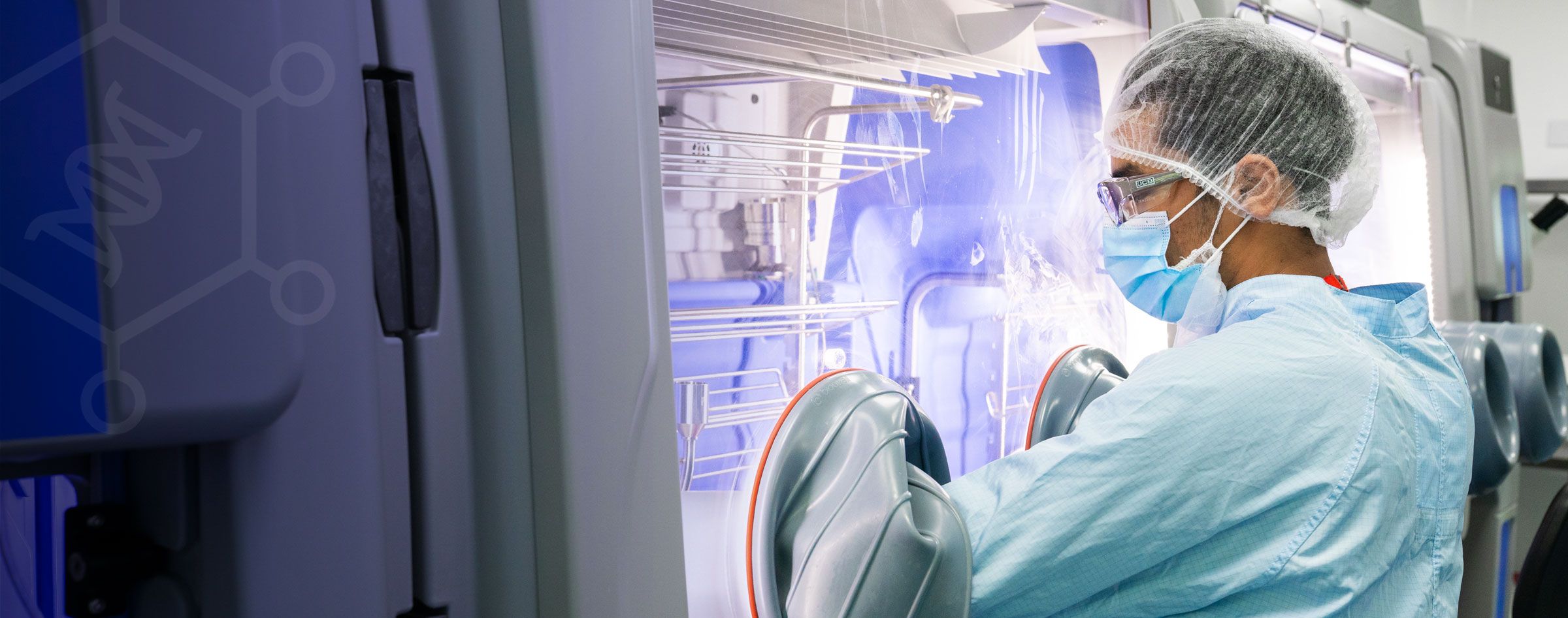 GTVF cleanroom scientist working with arms inside a glovebox manufacturing lentiviral vectors